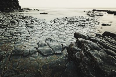 Scenic view of sea on rocks against sky. long exposure.