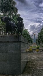 Statue by trees against sky