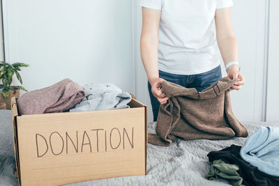 Midsection of woman standing on sofa at home