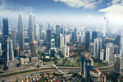 Aerial view of modern buildings in city against sky