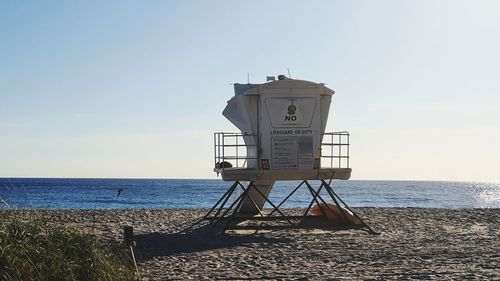 Lifeguard hut on beach against sky