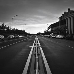 Cars on road in city against sky