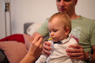 Mother and father feeding their little baby