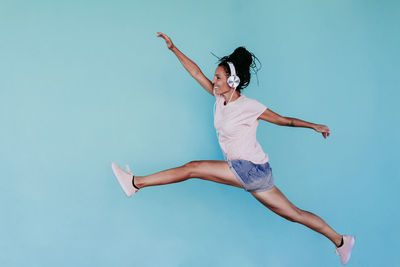 Woman jumping against blue background