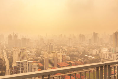 Aerial view from rooftop of high-rise building in poor weather, haze of pollution covers city