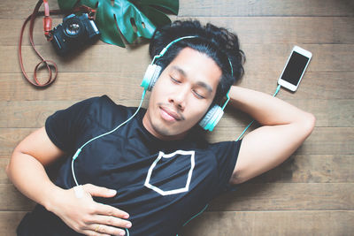 Young man using mobile phone on floor