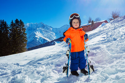 Portrait of young man skiing on snow covered mountain