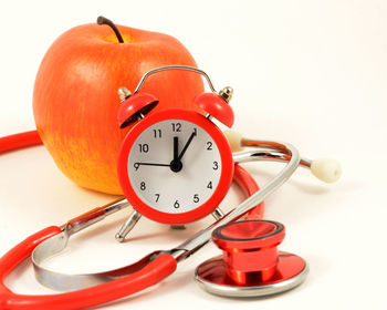 Close-up of clock on table against white background