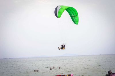 People in sea against sky