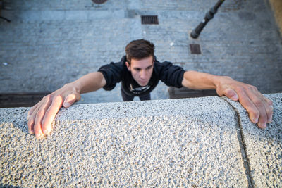 High angle view of man climbing concrete wall