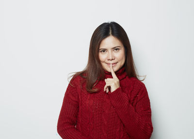 Portrait of a smiling young woman against white background