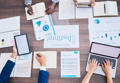 Cropped hands of business colleagues working on table