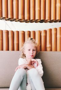 Portrait of cute girl sitting against decoration