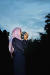 Woman standing on field against sky