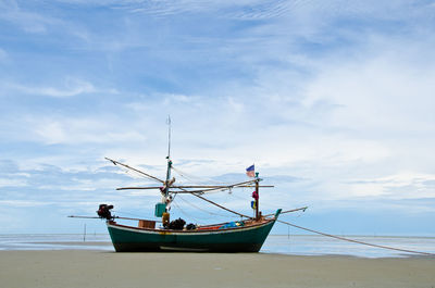 Boat moored on shore against sky