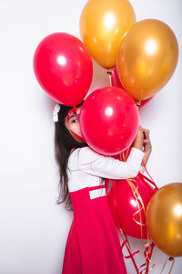 Rear view of woman holding balloons