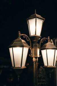 Low angle view of illuminated lamp at night