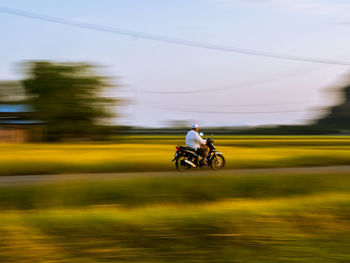 Man riding motorcycle against sky