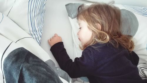 Close-up of girl lying on bed at home