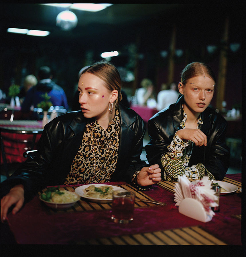 YOUNG WOMAN SITTING AT RESTAURANT