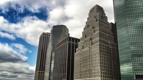 Low angle view of modern building against cloudy sky