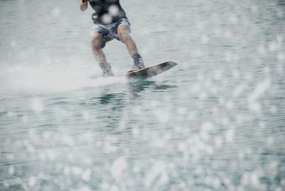Low section of a man surfing in the sea