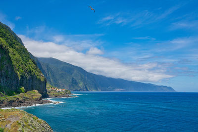 Scenic view of sea and mountains against sky