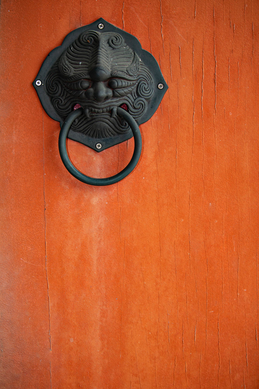 CLOSE-UP OF DOOR KNOCKER ON WALL