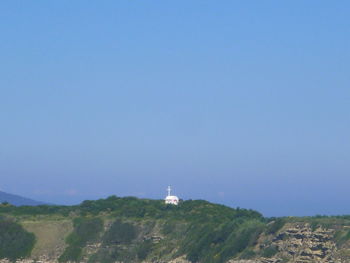 Lighthouse on mountain against clear sky