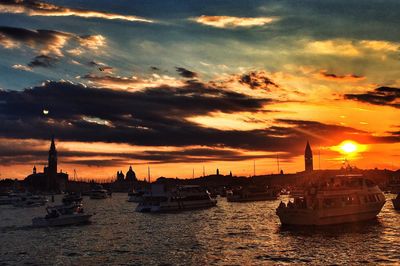 Boats moored in sea against sky during sunset