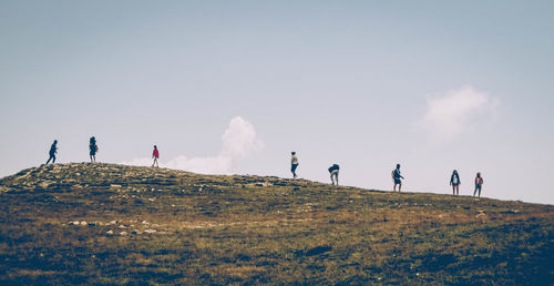 Panoramic view of people on land against sky