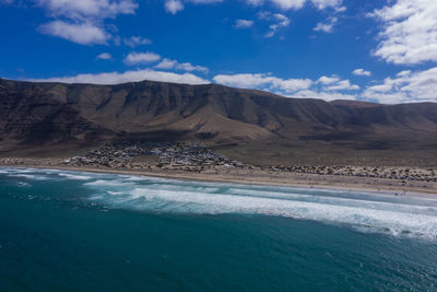 Panorama of the empty road through sandy and volcanic desert,lanzarote. view on the caleta de famara