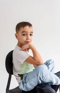 Boy child preschooler smiling and posing on gray background in photo studio