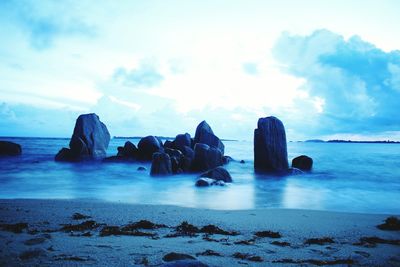 Scenic view of rocks on sea against sky