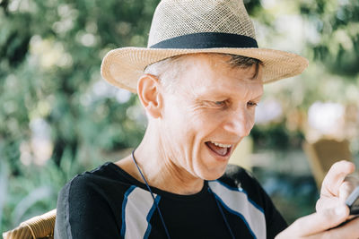 Close-up of happy senior man wearing hat