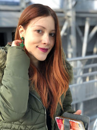 Portrait of smiling woman holding mobile phone