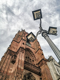 Low angle view of cross on building against sky