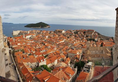 High angle view of townscape by sea against sky