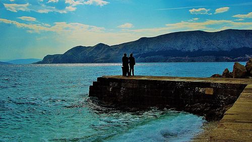 Silhouette man in sea against sky