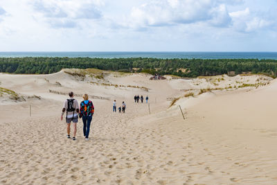 People at beach against sky