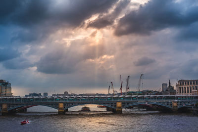 View of bridge over river against cloudy sky