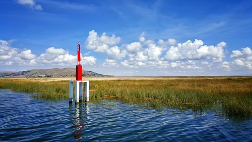 Water level gauge in river against sky