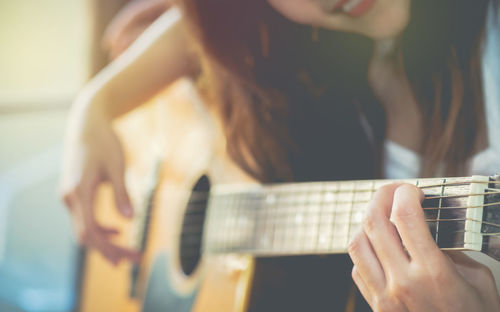 Close-up of woman playing guitar