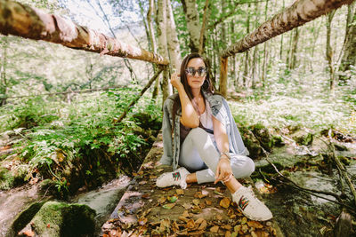 Portrait of smiling woman sitting in forest