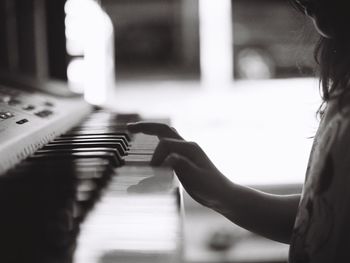 Midsection of girl playing piano