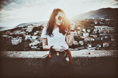 Young woman standing against cityscape