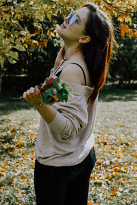 Side view of young woman holding flowers