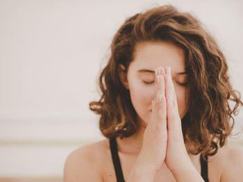 Close-up of young woman meditating in yoga studio