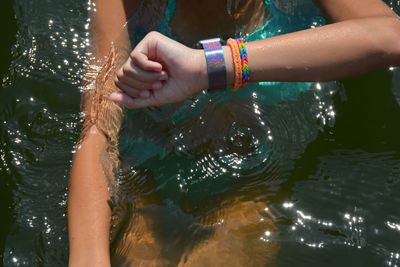 Midsection of woman checking the time while swimming in river