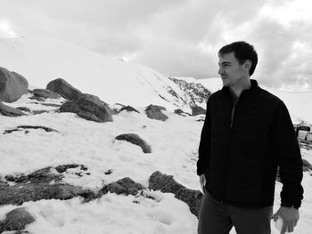 Man standing on snow covered landscape against sky